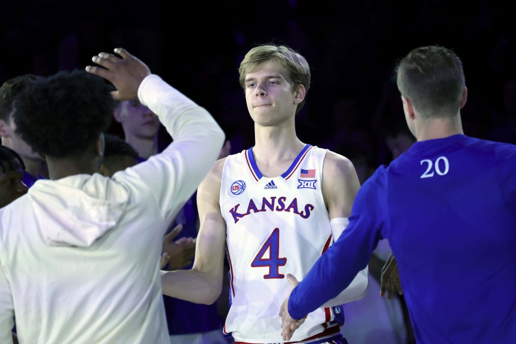 Kansas basketball star Gradey Dick high-fiving teammates in white jersey number 4 arena wallpaper