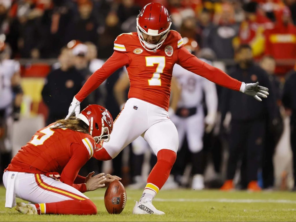 Kansas City Chiefs kicker Harrison Butker and holder Tommy Townsend field goal attempt under stadium lights Wallpaper