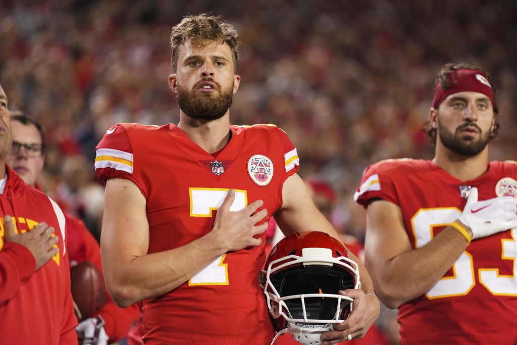 Kansas City Chiefs kicker Harrison Butker in red uniform holding helmet during national anthem Wallpaper