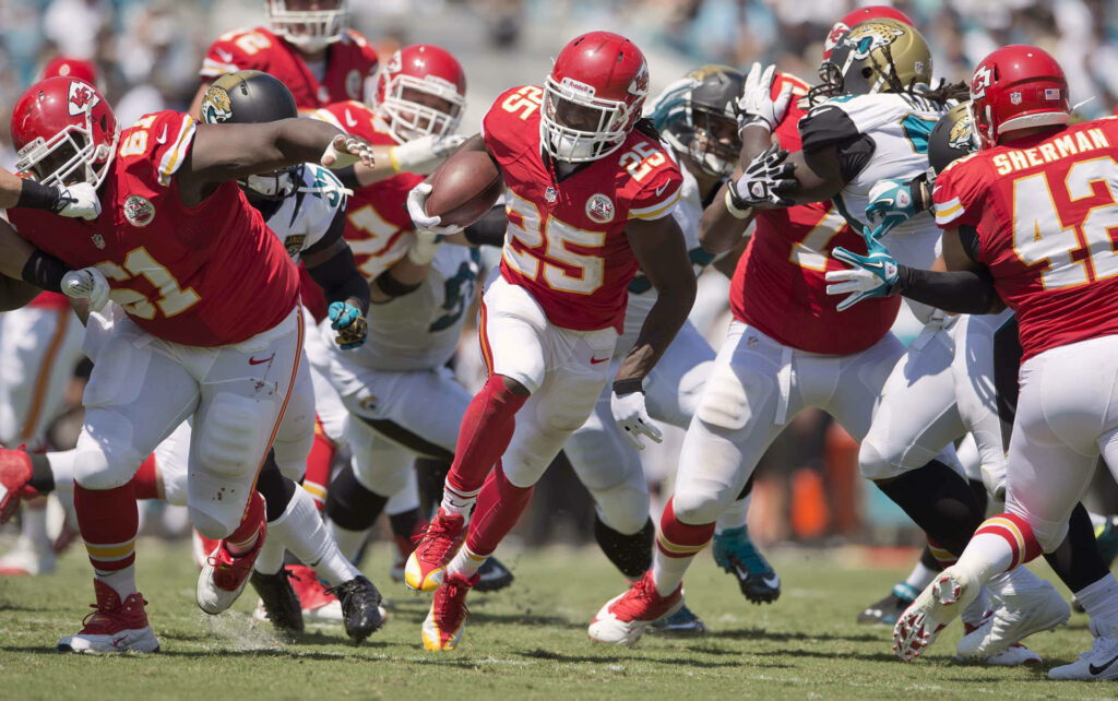 Kansas City Chiefs offensive line opens running path showing strength and teamwork NFL game Wallpaper