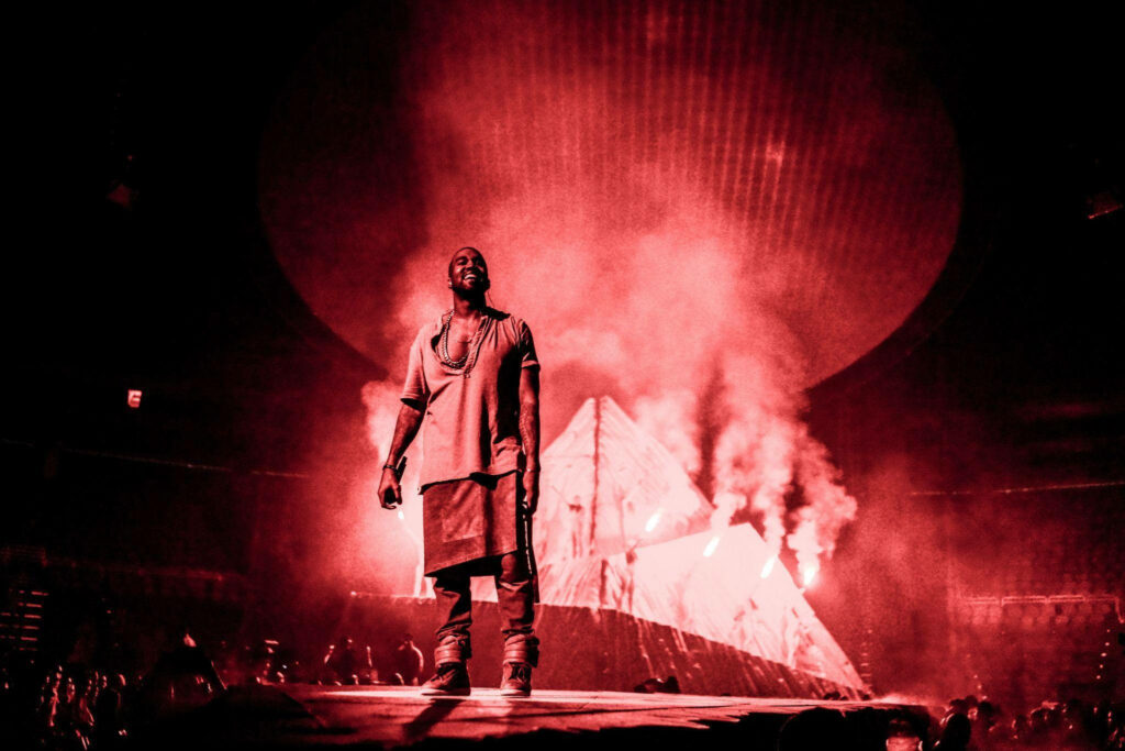 Kanye West: Dramatic Red-Lit Stage Performance Wallpaper Background