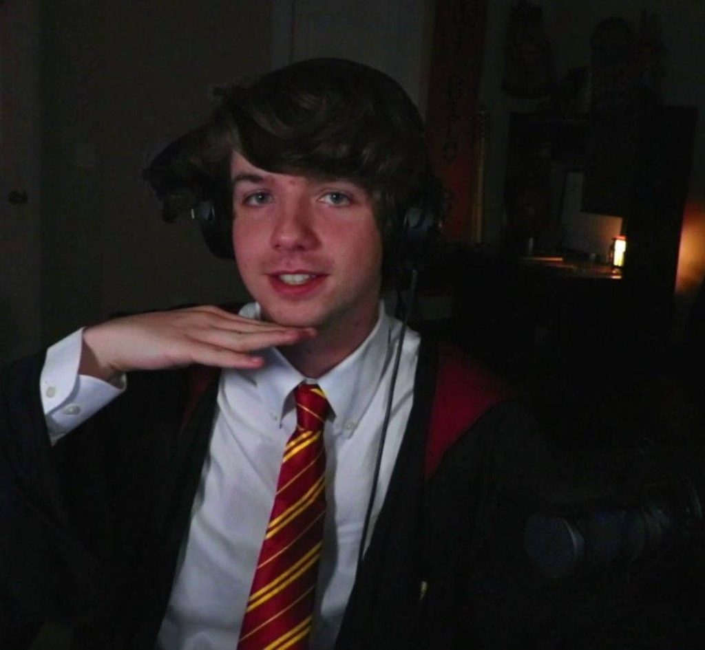 Karl Jacobs in realistic dim light wearing Gryffindor robe and red gold tie wallpaper