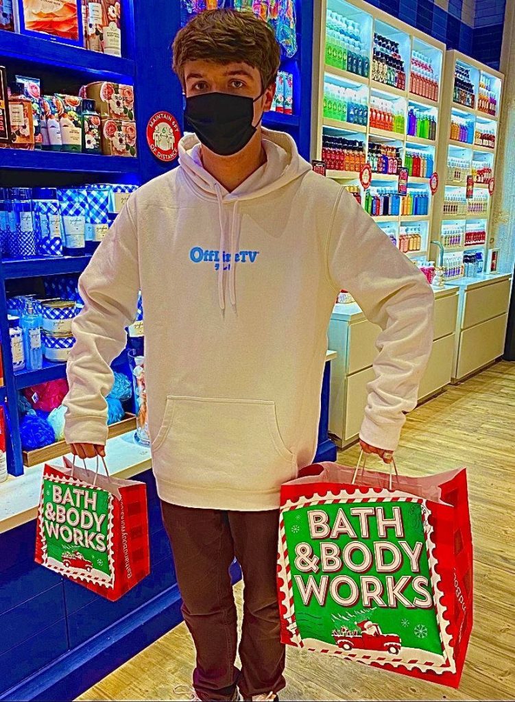 Karl Jacobs shopping Bath Body Works holding festive red bags wearing OfflineTV hoodie and mask Wallpaper