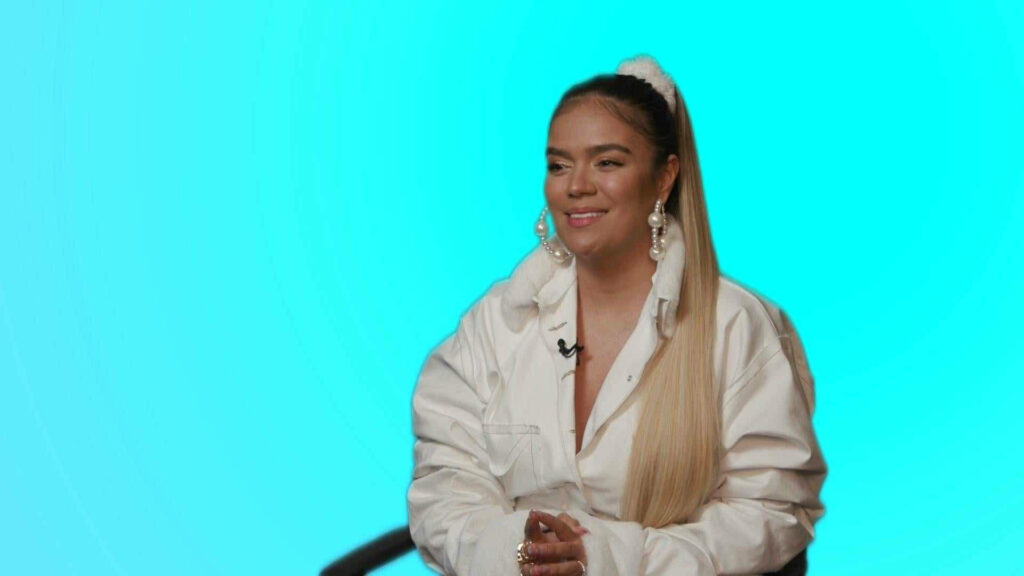 Karol G's Elegant White Outfit with Turquoise Background - Wallpaper