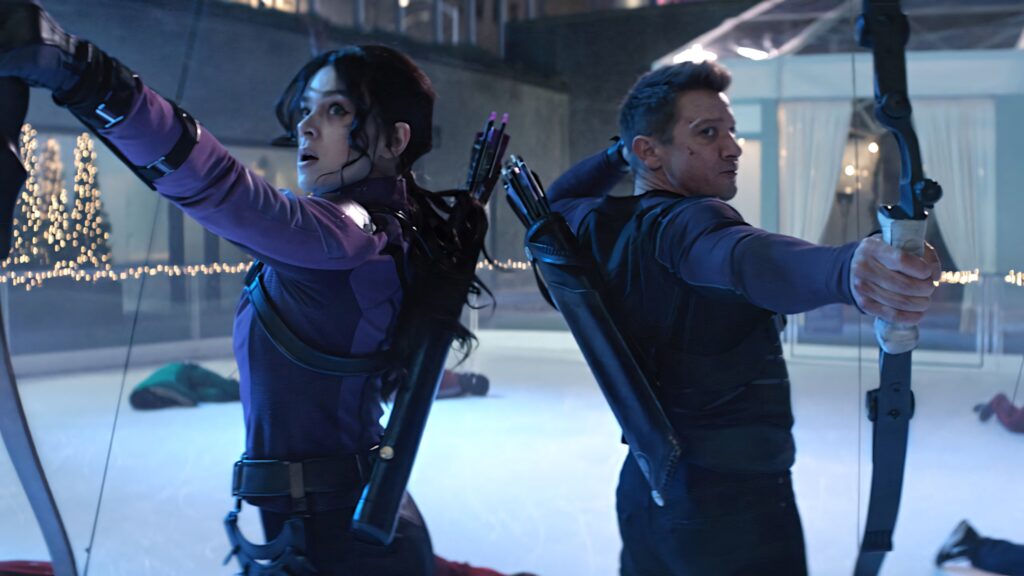 Kate Bishop and Hawkeye back to back with drawn bows on ice rink surrounded by defeated foes Wallpaper