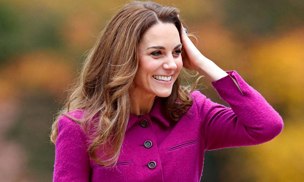 Kate Middleton in elegant deep magenta coat with autumn background vibrant warm wallpaper