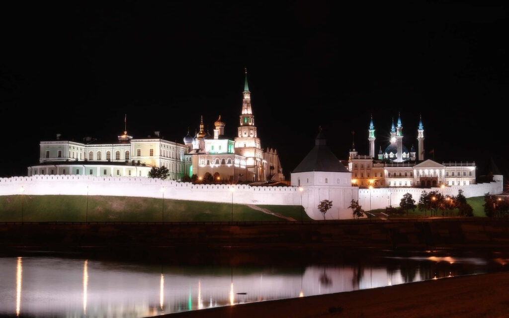 Kazan Kremlin night view illuminated reflecting over calm river under dark sky wallpaper background