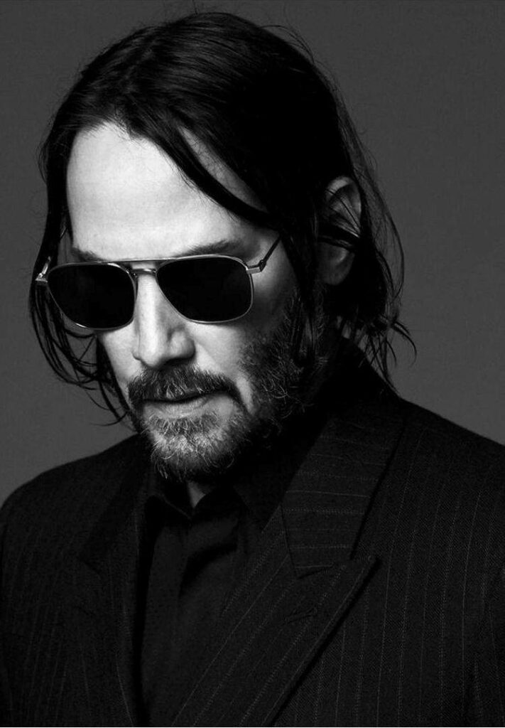 Charismatic Black-and-White Wallpaper of Keanu Reeves in Suit & Shades