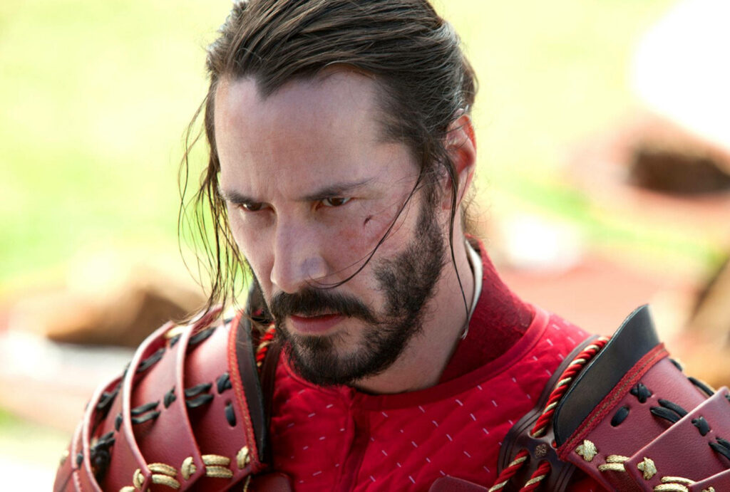 Keanu Reeves in Red Armor: Intense Action Movie Scene Wallpaper