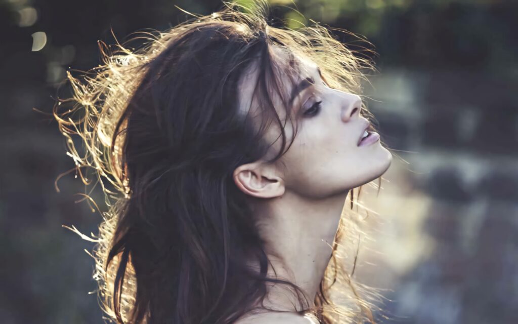 Keira Knightley side profile wallpaper with natural backlight highlighting hair and calm expression