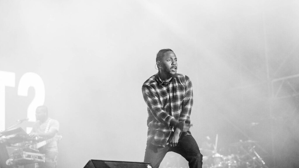 Kendrick Lamar's Energetic Black-and-White Stage Performance Wallpaper