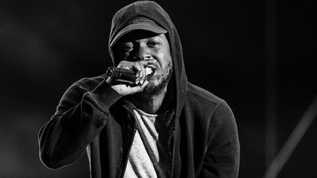 Kendrick Lamar Monochrome Wallpaper: Dynamic Stage Performance Background