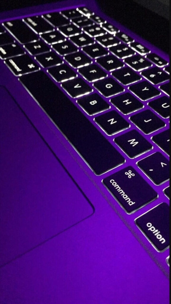 Keyboard Elegance: A Captivating Vertical Shot Showcasing the Illuminated Macbook Keyboard Against a Stylish Black Background Wallpaper