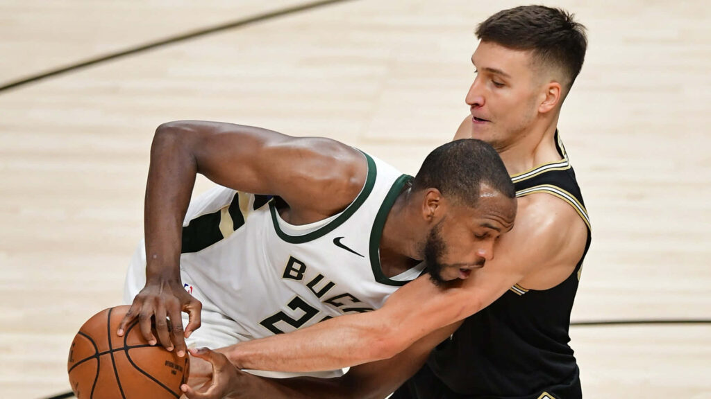 Khris Middleton battling Bogdan Bogdanović for basketball possession showcasing athleticism Wallpaper