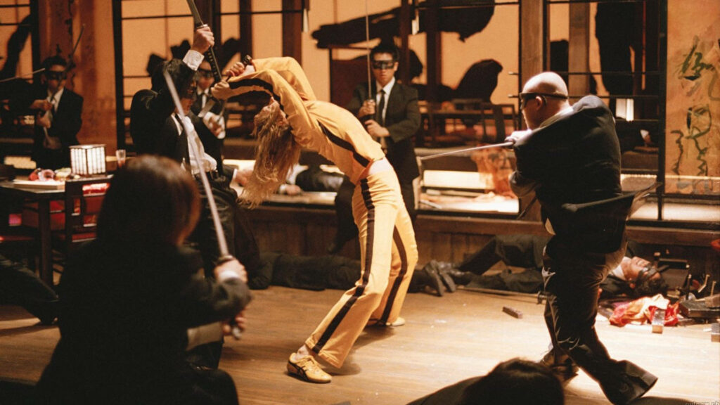 Kill Bill intense fight scene with yellow jumpsuit katana in dramatic dimly lit setting wallpaper