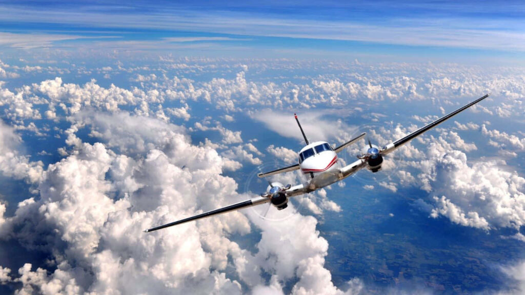 Skyward Soaring: Beechcraft King Air 350 Takes Flight Amidst Wispy Clouds Wallpaper