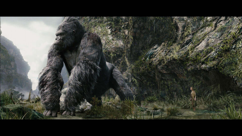 King Kong towering over human in rugged rocky landscape showing immense strength wallpaper