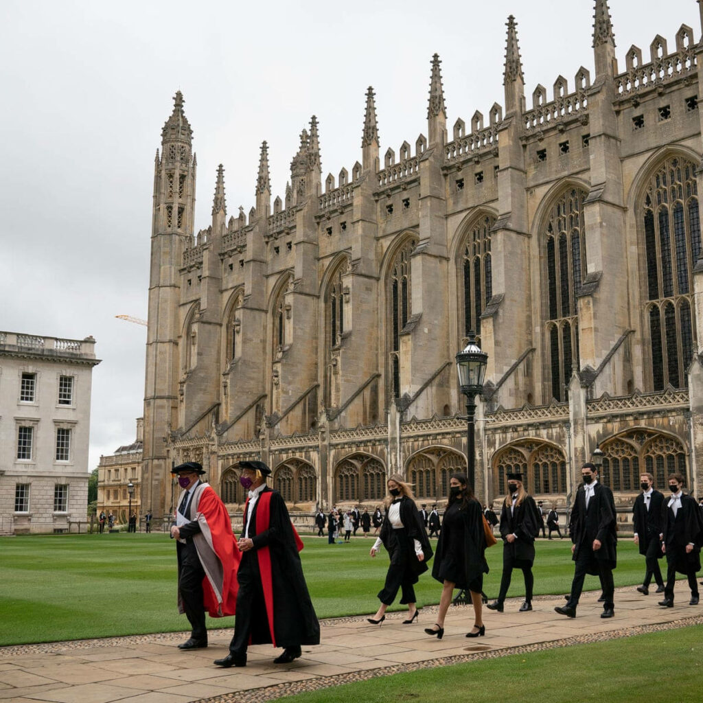 King's College Cambridge Graduation Day with graduates and Gothic chapel under cloudy sky wallpaper