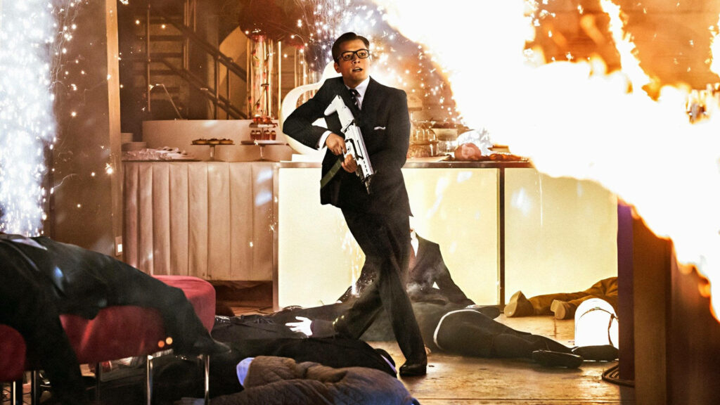 Kingsman 2 action scene wallpaper stylish agent with weapon in explosive intense background
