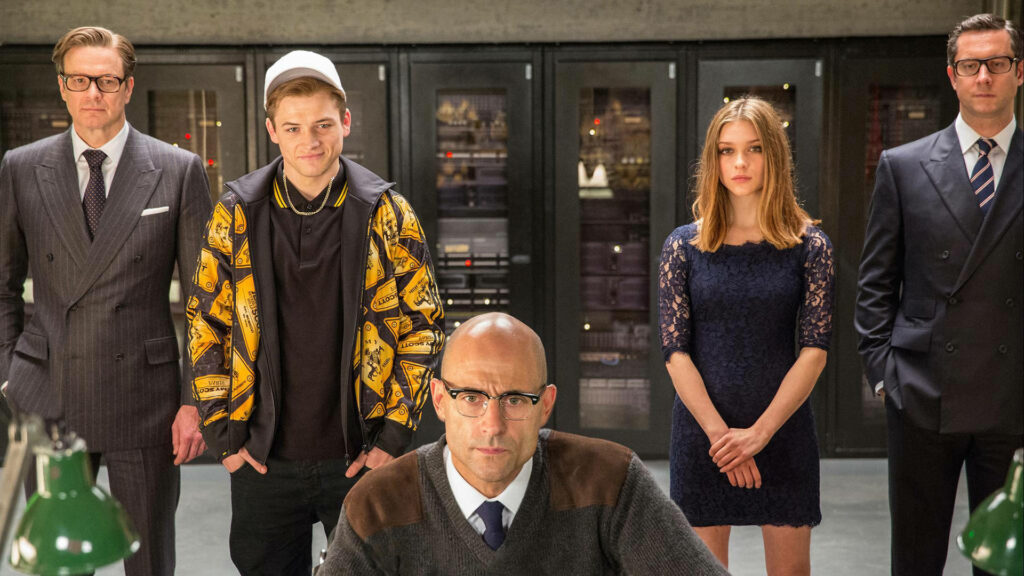 Kingsman agents in stylish suits stand confidently in high tech setting elite secret agents wallpaper