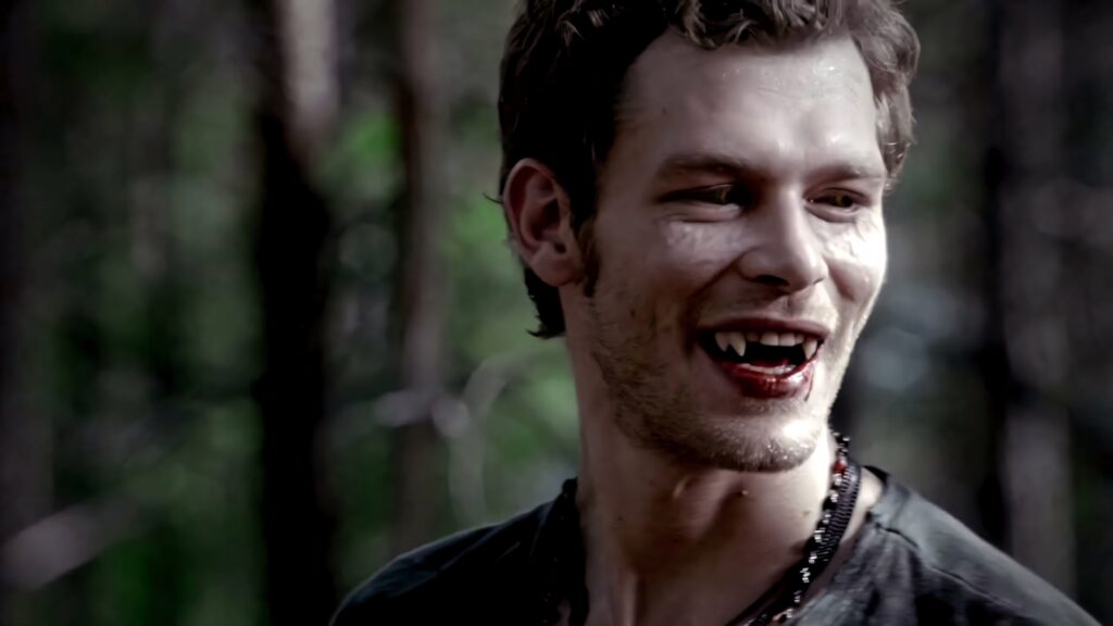 Klaus Mikaelson vampire fangs dark forest intense menacing powerful supernatural wallpaper background
