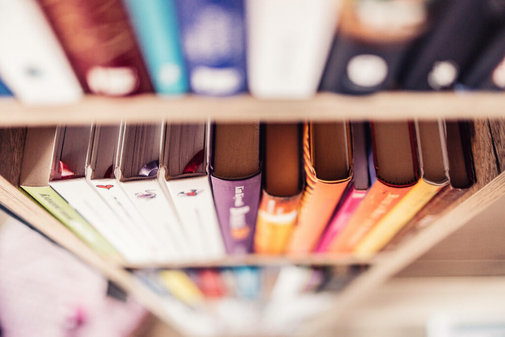The Wisdom Haven: Immersive Education Background Showcasing an Array of Books on a Bookshelf Wallpaper