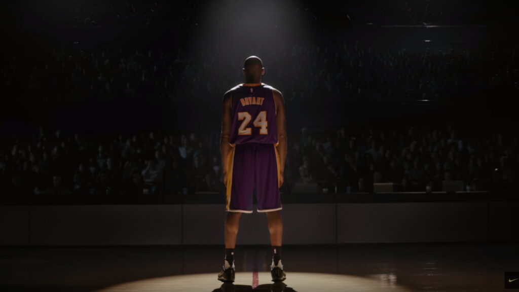 Kobe Bryant in #24 Lakers jersey spotlighted on basketball court HD wallpaper background