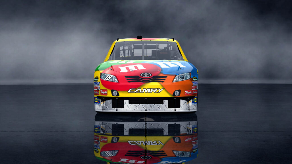Kyle Busch’s M&M's Toyota Camry with colorful candy design on smoky racing wallpaper background