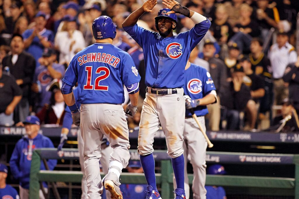 Kyle Schwarber and teammate high five in Chicago Cubs uniforms celebrating baseball victory wallpaper