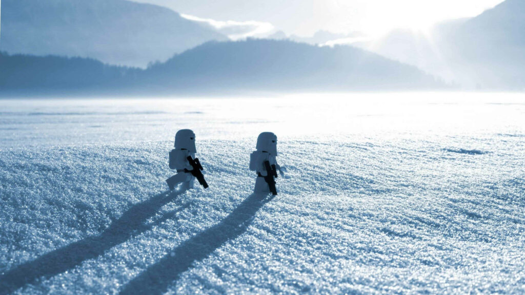 Two LEGO stormtroopers walk in snowy landscape bright sunlight distant mountains 4K wallpaper