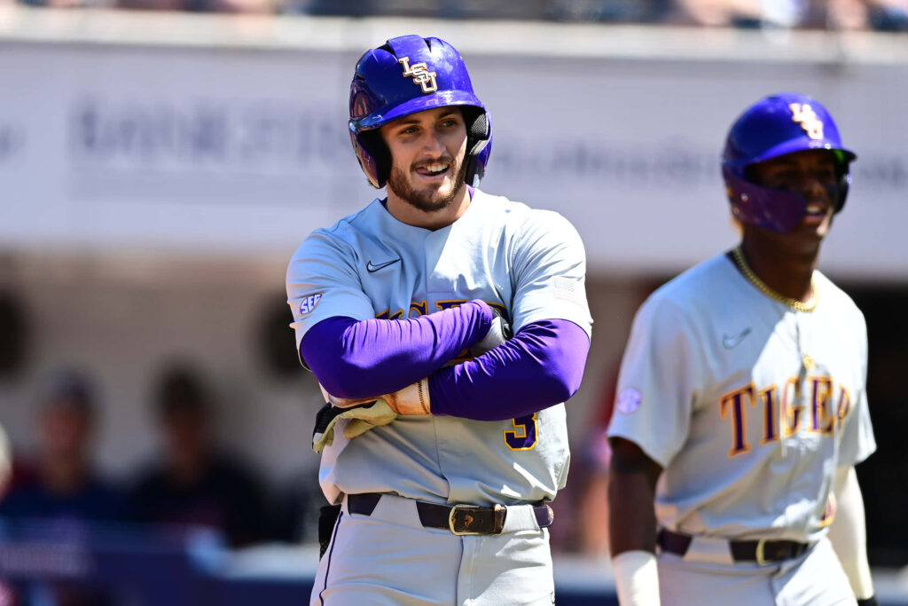 LSU Baseball player Dylan Crews smiling in gray purple uniform vibrant game wallpaper background