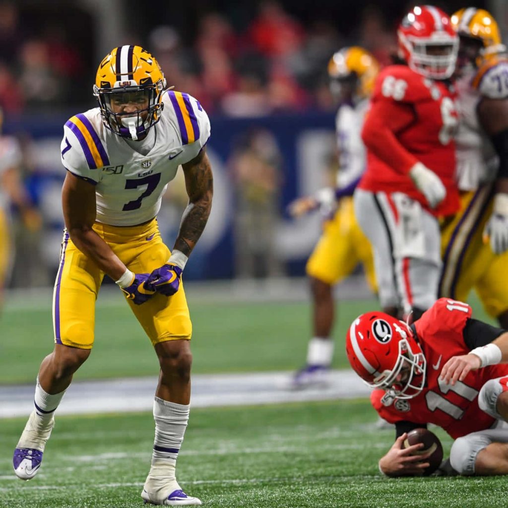 LSU safety Grant Delpit in purple gold uniform focused in defensive stance vs Georgia player Wallpaper
