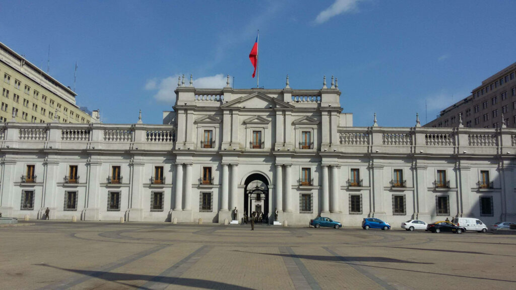 La Moneda Palace Chile neoclassical architecture with Chilean flag under clear blue sky wallpaper