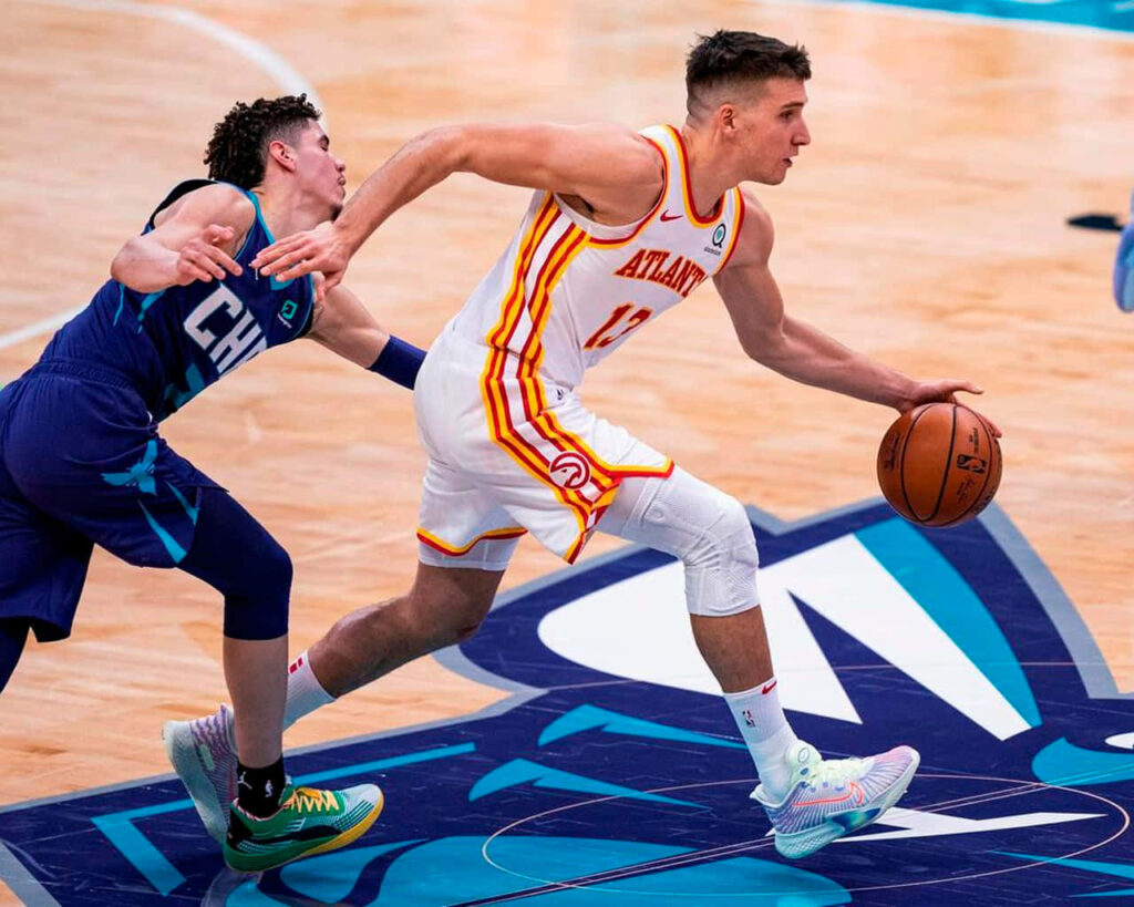 LaMelo Ball defends Bogdan Bogdanović driving ball in intense Hornets vs Hawks NBA game action Wallpaper