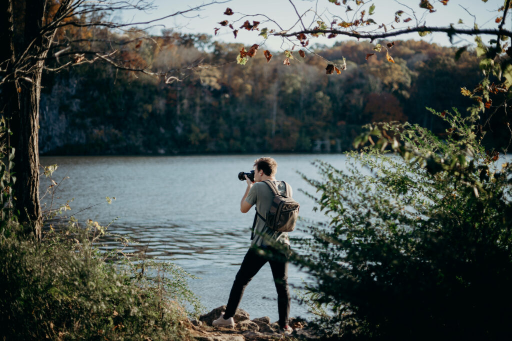 The Adventurous Shutterbug: Exploring Nature's Beauty with a Backpack and Camera Wallpaper
