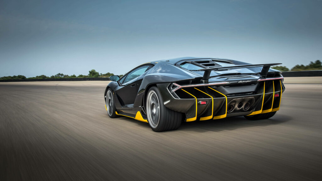 Lamborghini sports car speeding on open track showcasing sleek design powerful performance 4k Wallpaper