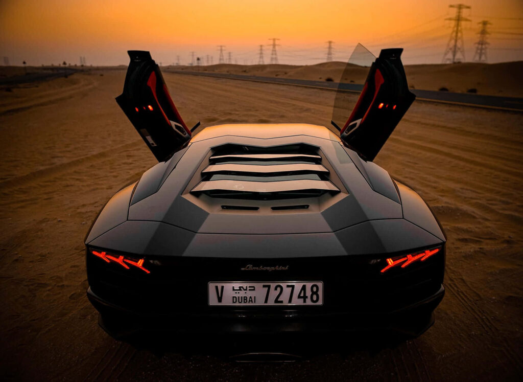 Lamborghini with open doors parked on desert road at sunset dramatic luxury sports car wallpaper