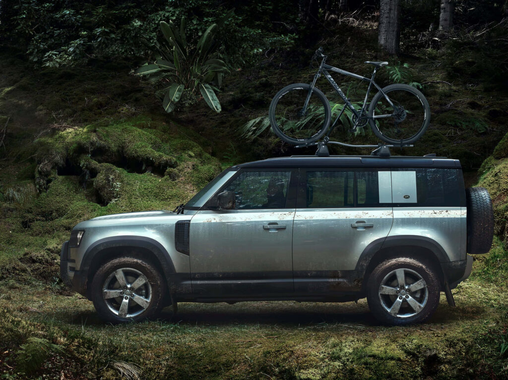 Land Rover Defender Adventure Wallpaper: Rugged Forest with Bicycle