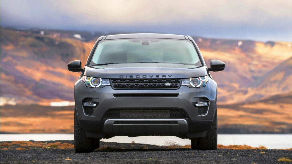 Land Rover Discovery parked outdoors with mountains and cloudy sky scenic background wallpaper