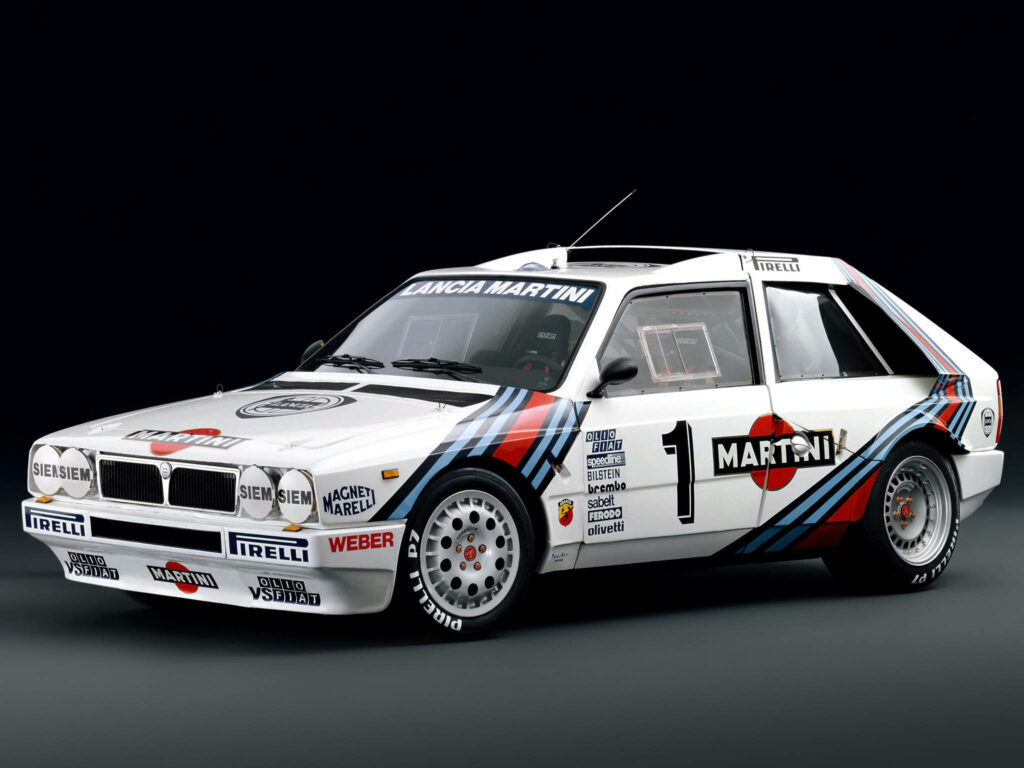 Stylish Martini Decal Adorns the White Body of Lantia Delta Dirt Rally Car: Captured in a Striking Background Wallpaper
