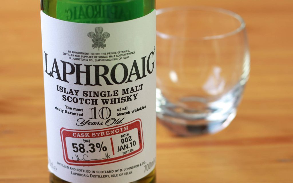 Laphroaig 10-Year-Old Cask Strength Islay Single Malt Scotch Whisky bottle with label and tumbler background Wallpaper