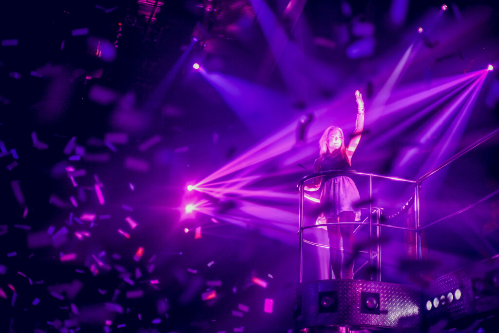 Exuberant Club-Goer Reveling Amidst Enchanting Purple Hues and Rain of Celebration Wallpaper