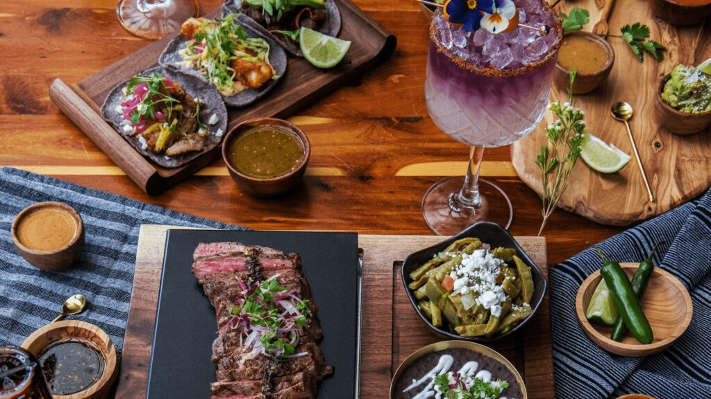 Luxurious Parrilla Steak Dinner Wallpaper with Colorful Sides & Drinks