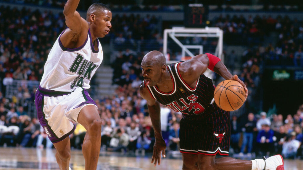 Tongue-Tied Duel: Michael Jordan vs Ray Allen in a High-Stakes NBA Clash - Epic Action Frozen in Time Wallpaper