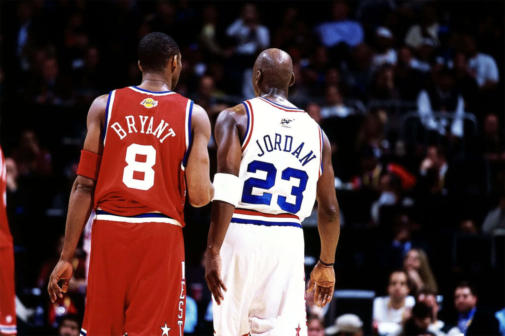 Legendary NBA Icons Unite: A Captivating Image of Michael Jordan and Kobe Bryant in the Background Wallpaper