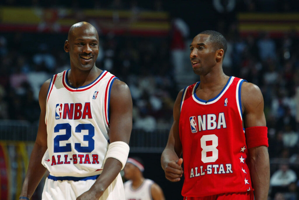 Legends Collide: Michael Jordan and Kobe Bryant on the Basketball Court Wallpaper
