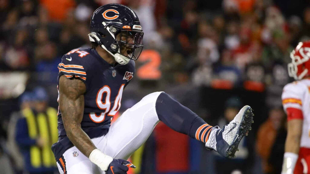 Leonard Floyd Chicago Bears celebrating energetically raising leg in navy blue uniform stadium background Wallpaper