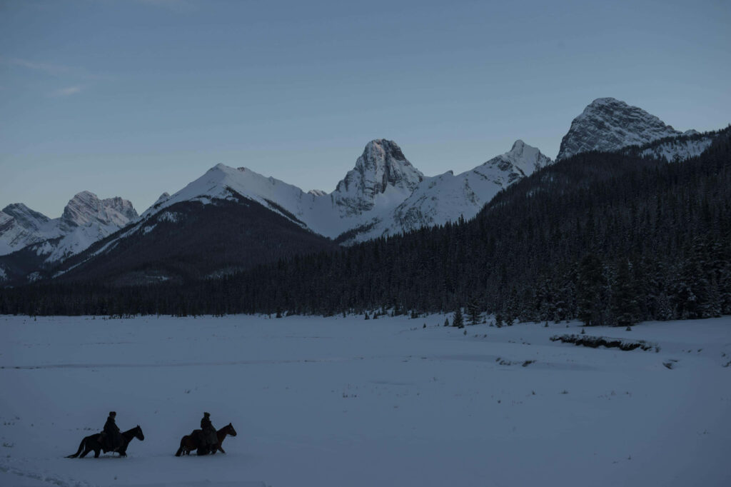 Leonardo DiCaprio riding horseback in snowy wilderness with towering mountain landscape wallpaper