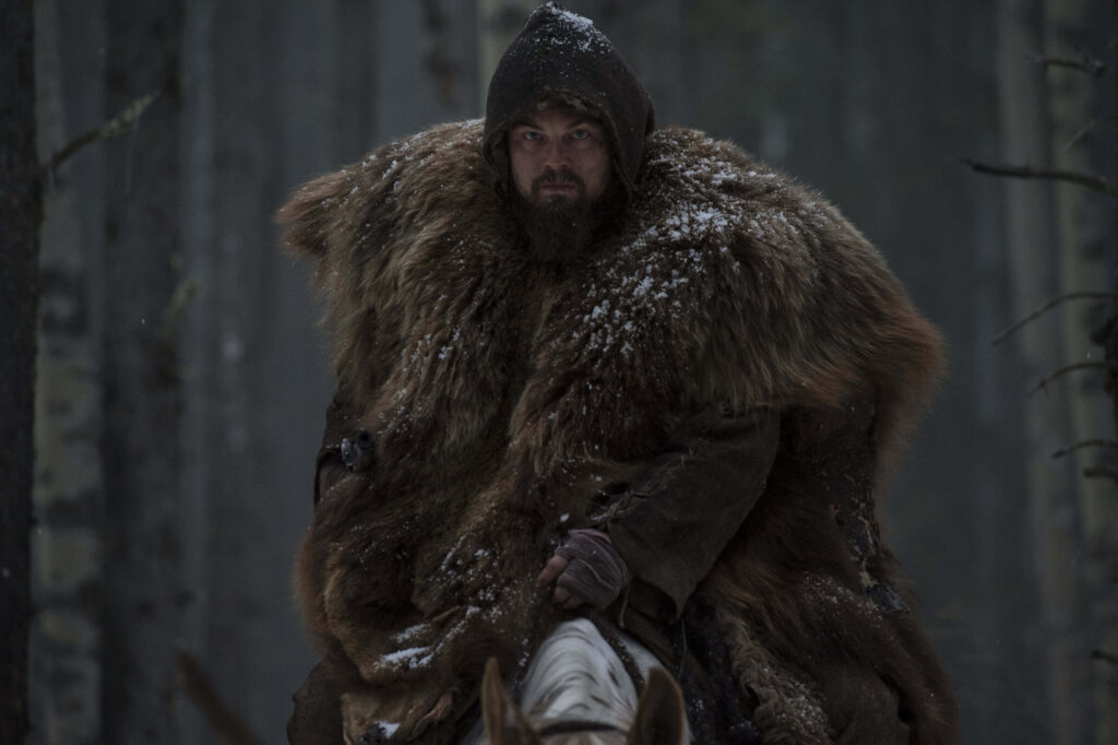 Leonardo DiCaprio as Hugh Glass in The Revenant trudging snowy wilderness in furs wallpaper