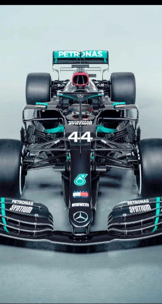 Lewis Hamilton confidently seated on Mercedes AMG Petronas Formula 1 car with sleek design wallpaper